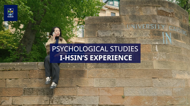 Student sitting on a wall on University Avenue