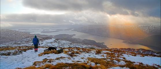 Lomond and surrounding mountains with a walker in the foreground