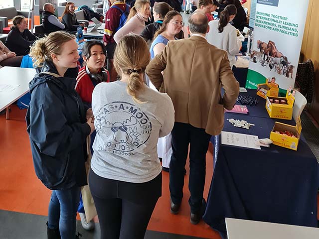 A large group of people networking surrounded by banners