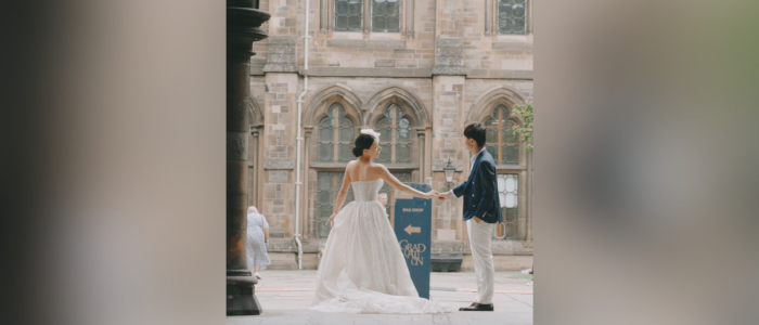 A bride and groom posing for a photo in the cloisters at UofG