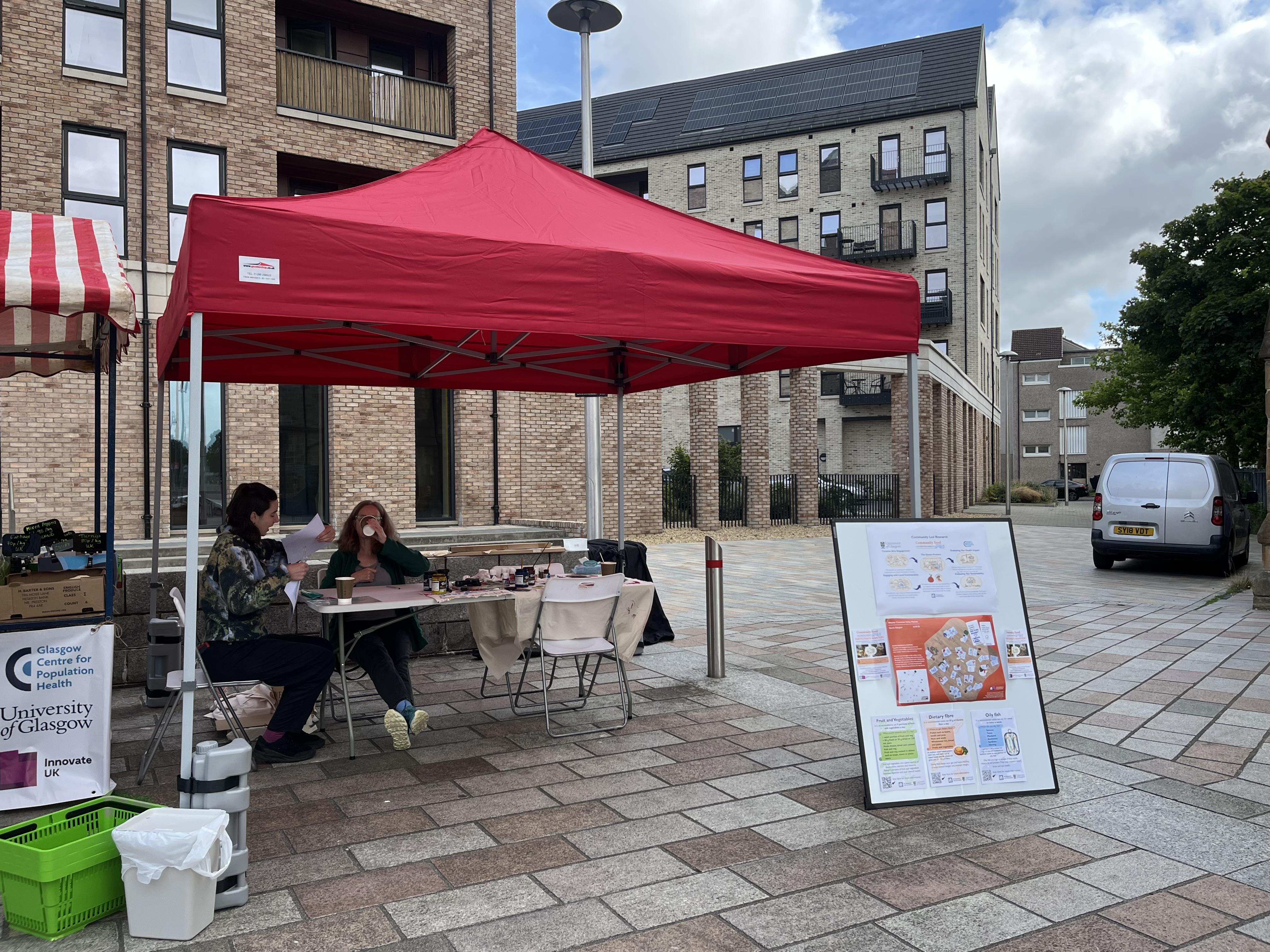 researcher discussing research project with participant at a market stall