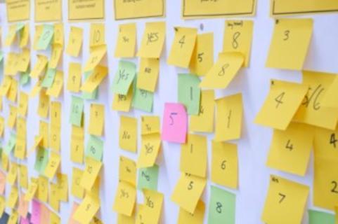 a wall of Post It notes with numbers written on them