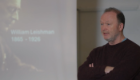 Professor Mike Barrett speaking beside a presentation slide showing Sir William Leishman and the dates 1865–1926.