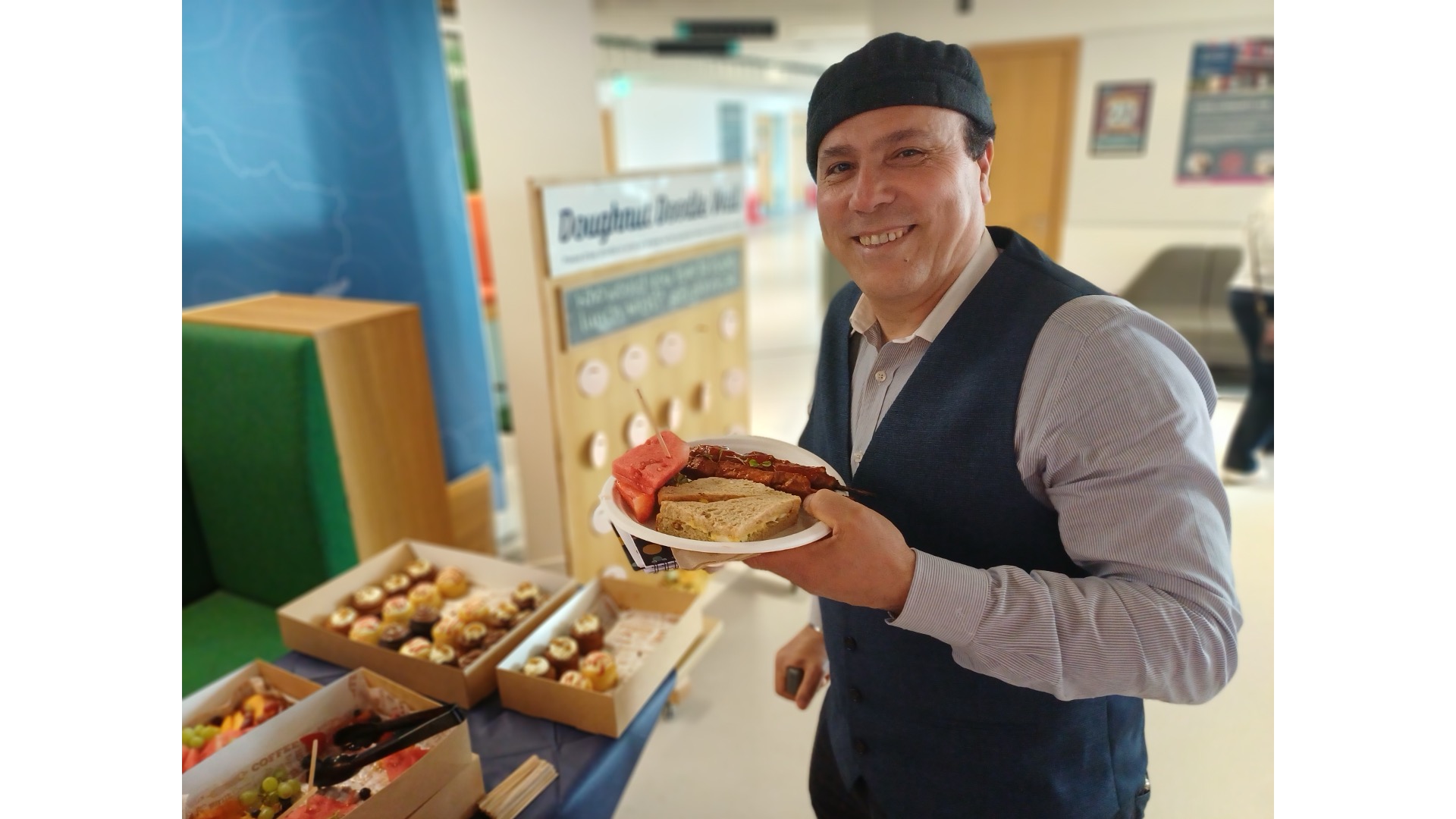 Photograph of a man holding a plate at a buffet.