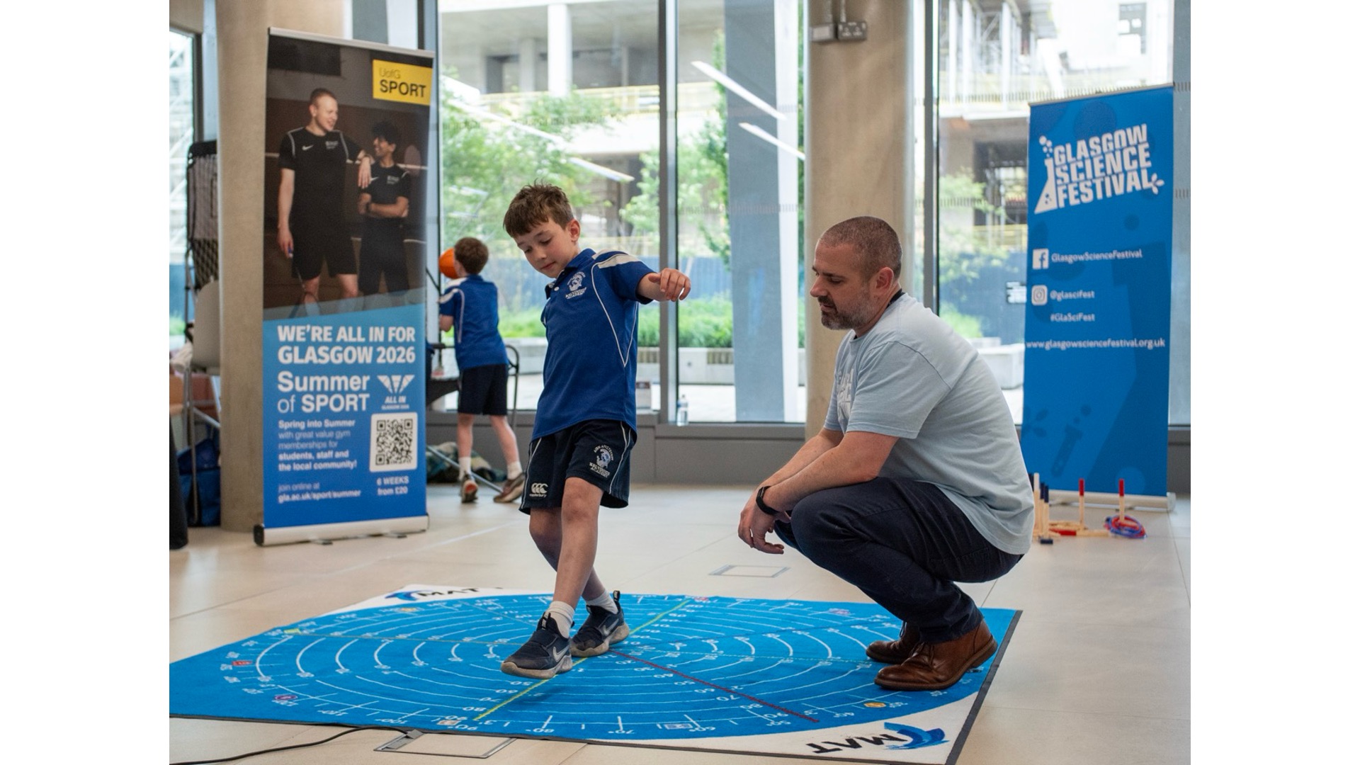 Photograph of a GSF volunteer with a child on a sports mat.