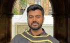 Thanus Govindan Murugan wearing a graduation gown outside
