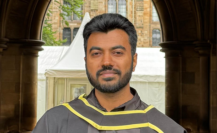 Thanus Govindan Murugan wearing a graduation gown outside
