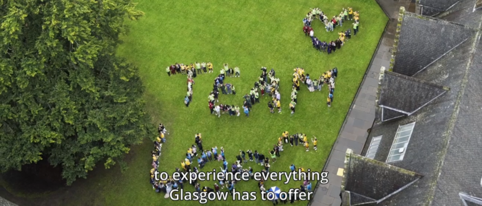 A video thumbnail witth students standing on grass in the east quad spelling out the words Team UofG with a heart shape