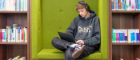 A student sitting with a laptop in a nook in the UofG library