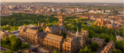 A drone shot of the gilbert scott tower at sunset with Kelvingrove Park in the background