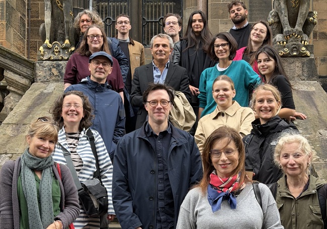 A group image of people standing on an outside stone staircase