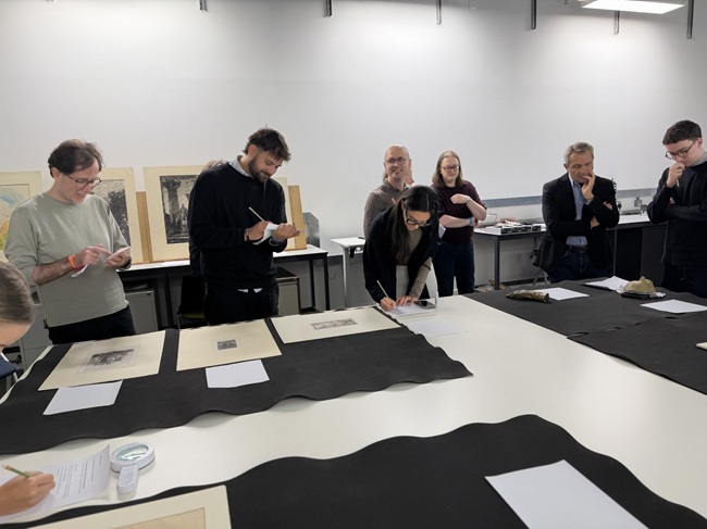A group of people examining artefacts on a table