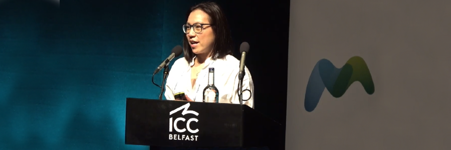 Professor Antonia Ho delivers her 2026 Fleming Prize lecture at the Microbiology Society Annual Conference in Belfast, speaking at a lectern on stage.