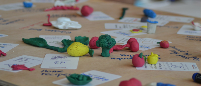 Creative arts based engagement workshop. Clay models on wooden tabletop.