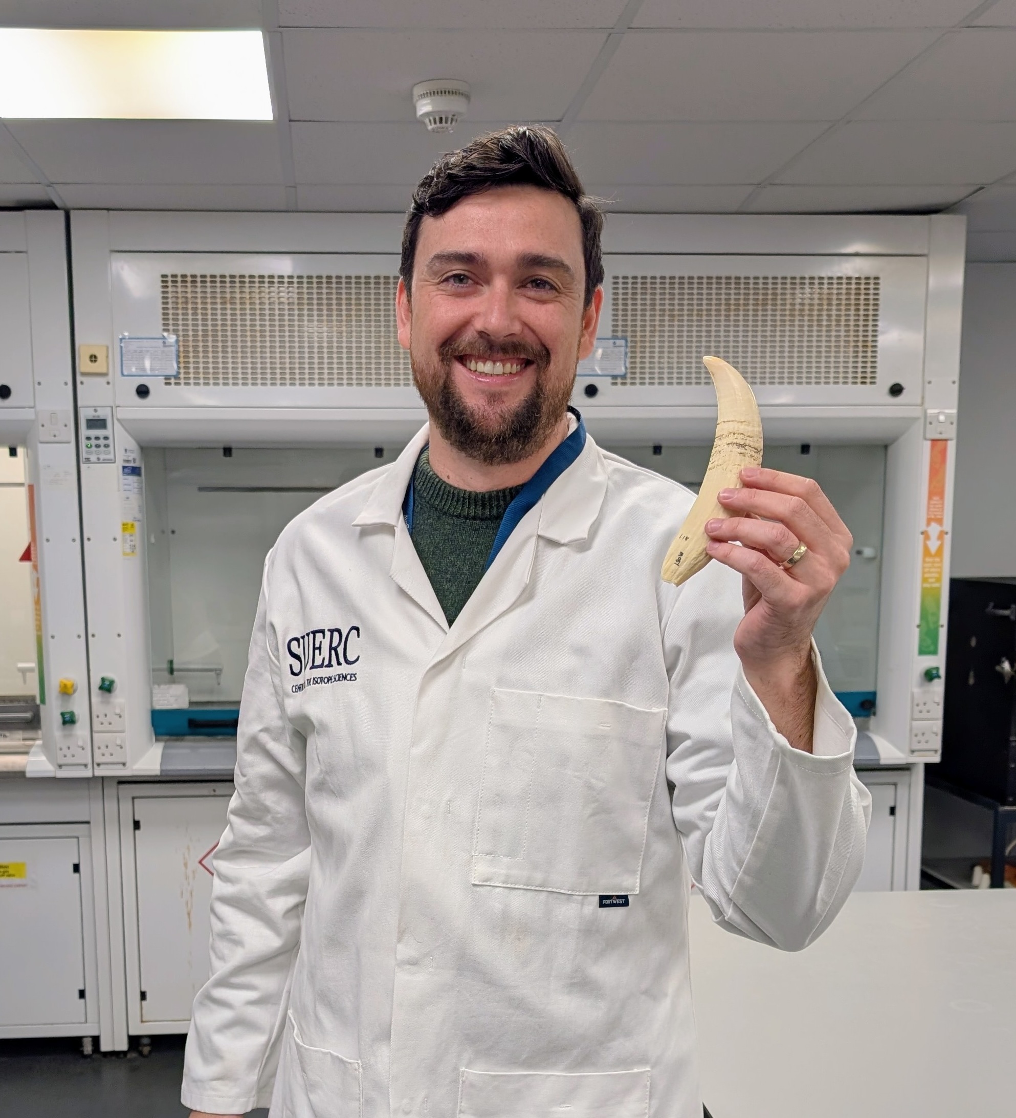 Dr Kieran Tierney holds a whale tooth at SUERC