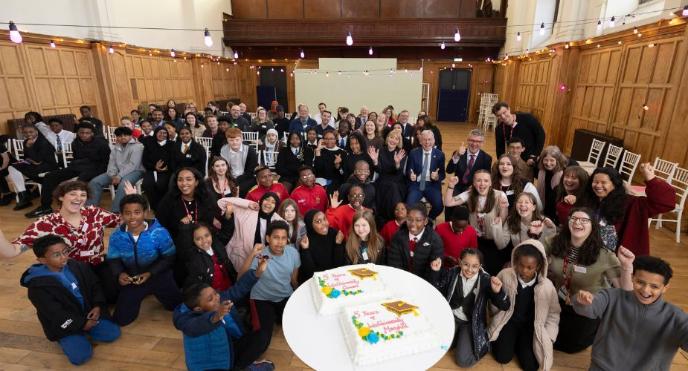 Students, their families and staff from IntoUniversity gathered round a celebration cake to mark the fifth anniversary