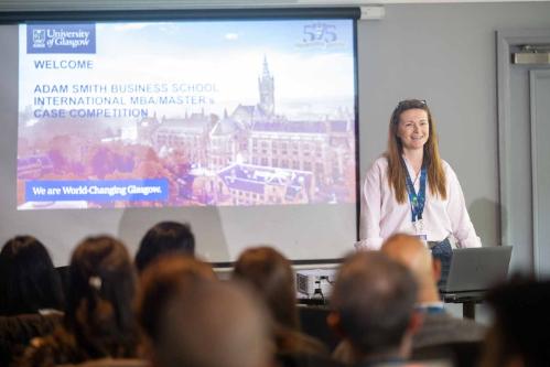 Director of learning and teaching, Alison Gibb, standing at the front of the audience, welcoming international competitors to the International Case Competition