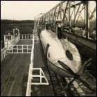 Photographic print showing completed Bennie railplane car mounted on aerial network - railplane is a four-bladed propeller version, c1930. (GUAS Ref: DC 85/3/20. Copyright reserved.) 