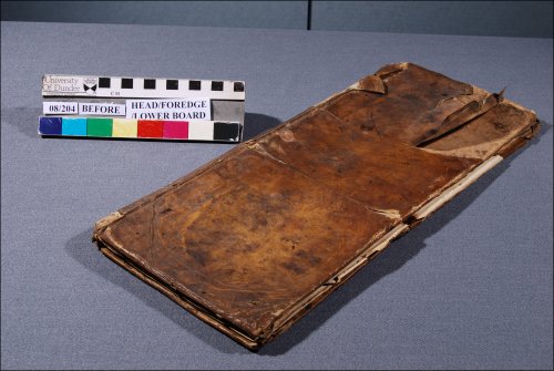 This photograph shows a three-quarter view of the front cover with significant damage caused by handling and changes in temperature and humidity before conservation treatment. (GUAS Ref: UGC 182. Copyright reserved.) 