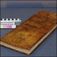 This photograph shows a three quarter view of the front cover of the logbook after conservation treatment.  (GUAS Ref: UGC 182. Copyright reserved.) 