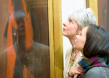 Two women looking at a painting