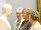 Three women looking at a portrait bust