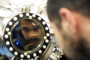 A student looking into the PLD vacuum chamber