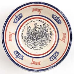 a ceramic bowl viewed from above. The image on the base of the bowl is of marching scottish soldiers wearing kilts. There is an inscritption: 