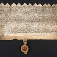 Image of a charter, handwritten ink on parchment, with a seal attached. Ref BL 148.