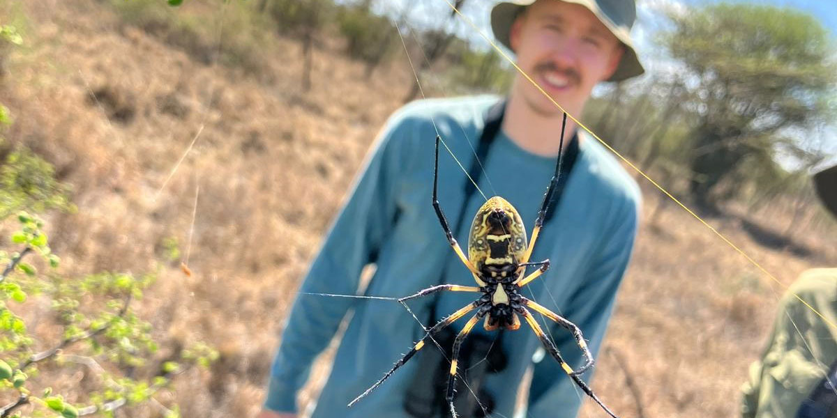 A student taking a photo of a spider