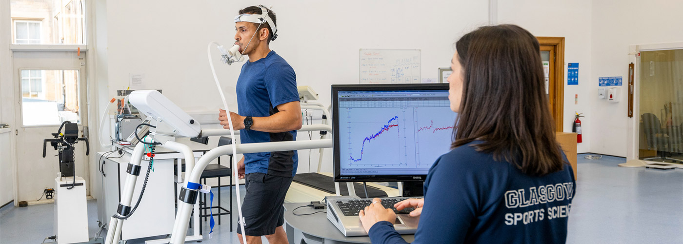 Sportsman with mask running on treadmill. Male athlete in sports science lab measuring his performance and oxygen consumption.