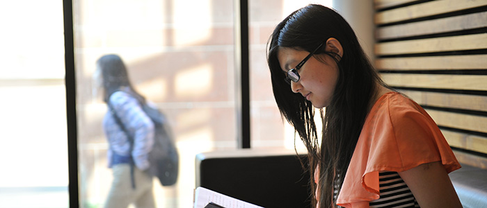 female student reading in library