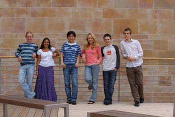 Line of students standing against wall, some international