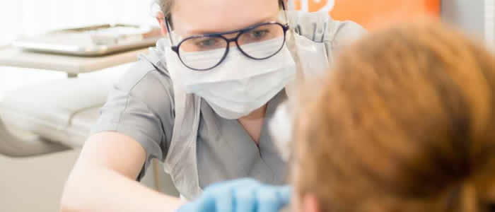 horizontal banner - student checking inside a patient's mouth