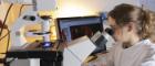 Researcher with microscope and monitor