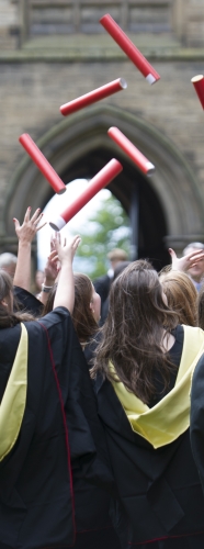 Graduated students throwing certificates in the air