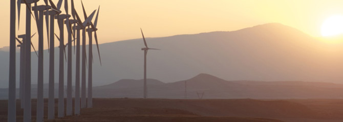 aligned windmills for renowable electric production at sunset