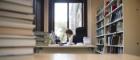 a staff member at work in University Gardens with books in the foreground