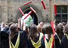 Students at graduation throwing certificates in the air