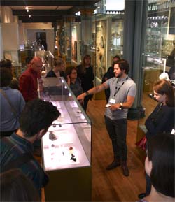Student leading tour for visitors and new recruits to Museum studies Course, 2015. Shows group around Cabinet of precious gems.