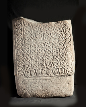 Fragment of stone cross with celtic knot pattern.