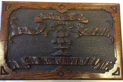 The Lid of a box carved from the timbers of the Old College. Decorated with carving of the GU crest and the words: 