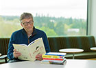 Person reading the newspaper and wearing glasses