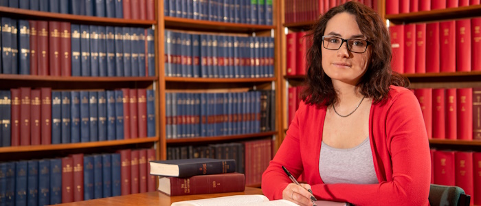 A student sitting in front of bookshelves in the Law Library