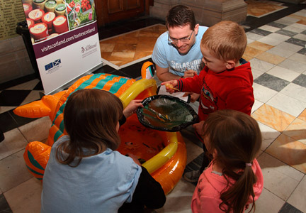 Photograph showing 2 GSF volunteers with 2 children fishing in the paddling pool at kelvingrove