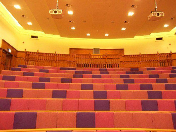 Raked lecture theatre with fixed seating, including a balcony