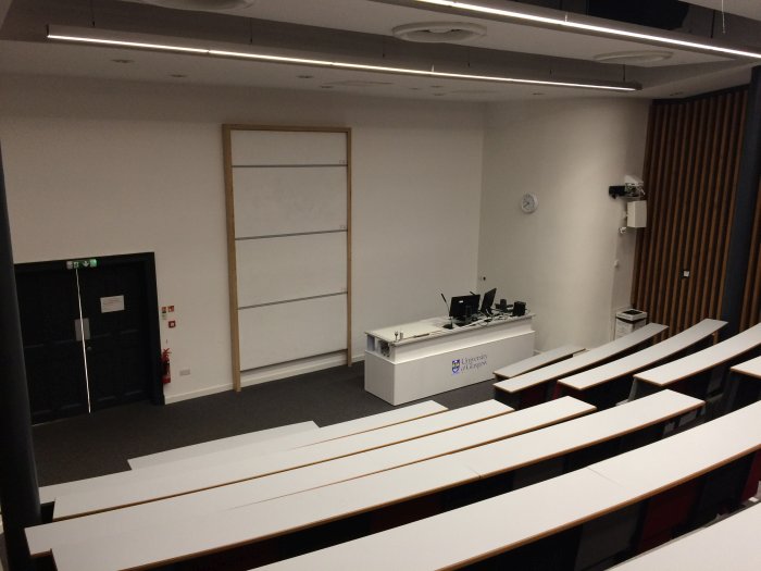 Raked lecture theatre with fixed seating, whiteboard and PC