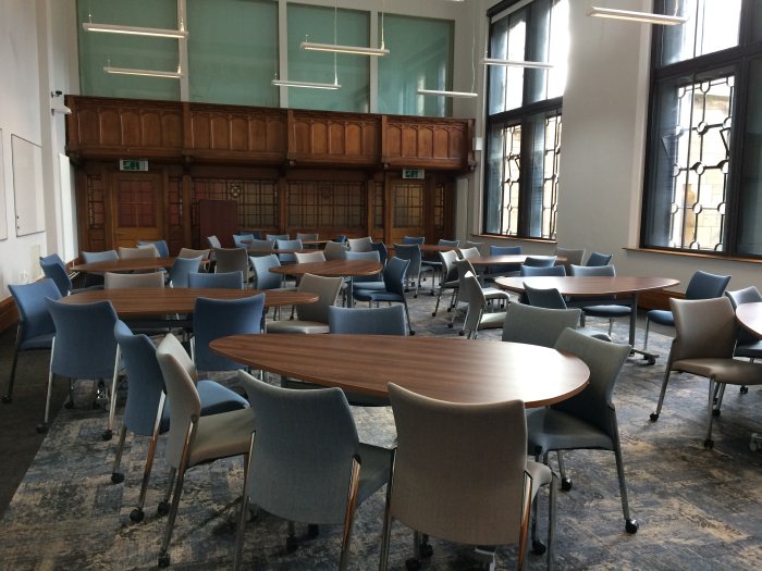 Flat floored teaching room with groups of teardrop tables and chairs