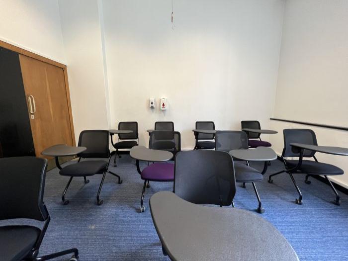 Flat floored teaching room with tablet chairs.