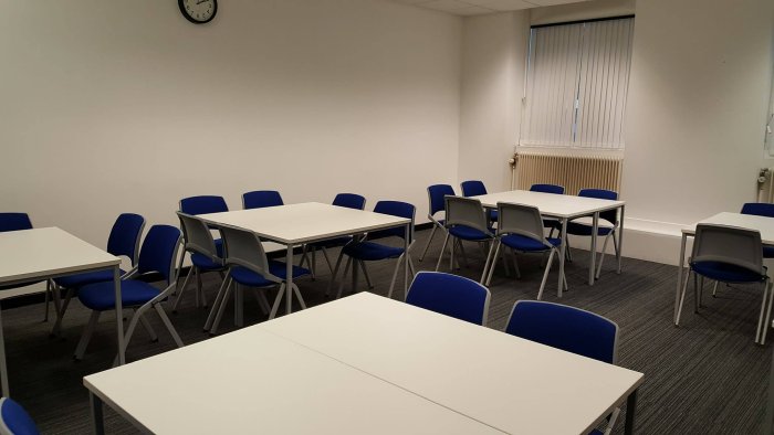 Flat floored teaching room with groups of tables and chairs